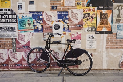 Black bike parked in is full of the wall posters
